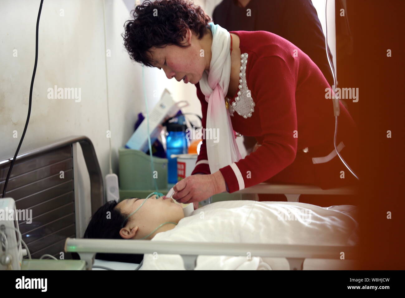 Sun Guofang, bottom, is attended by a relative on a sickbed after a transplant surgery to donate one of her kidneys to her uremia-stricken husband Li Stock Photo