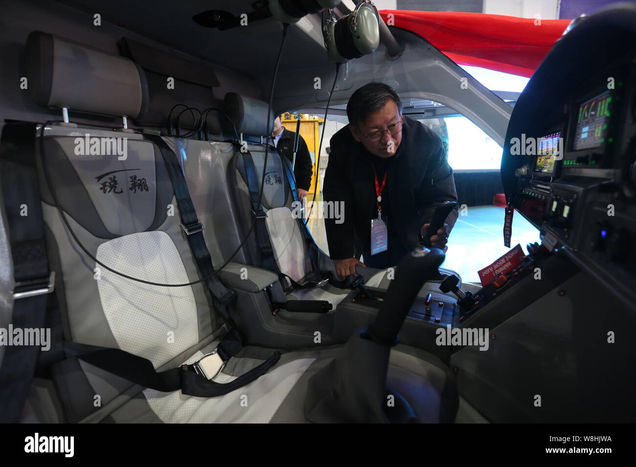 A visitor looks at the interior of China's first electric light sport aircraft RX1E Ruixiang on display during the sales contract signing ceremony at Stock Photo