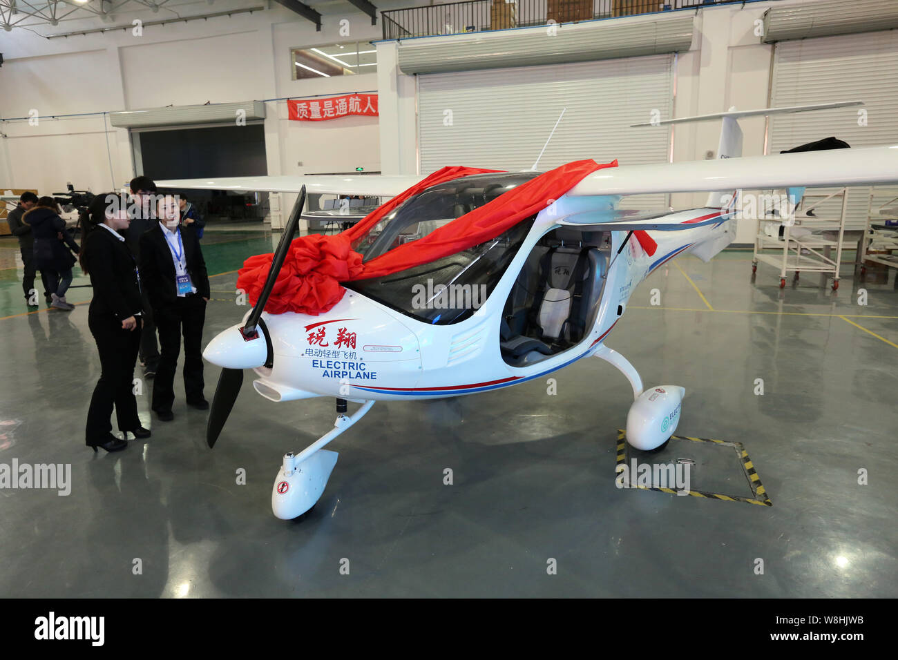 Visitors look at China's first electric light sport aircraft RX1E Ruixiang on display during the sales contract signing ceremony at Shenyang Aerospace Stock Photo