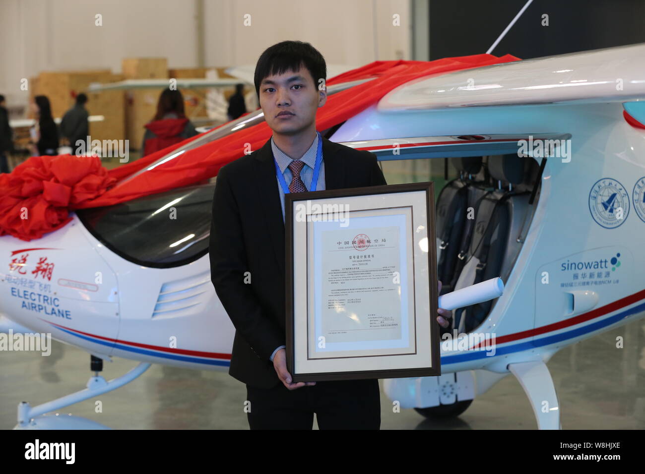 A Chinese employee poses with the Type Design Approval Certificate of China's first electric light sport aircraft RX1E Ruixiang issued by Civil Aviati Stock Photo