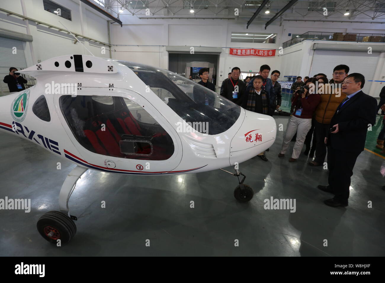 Visitors look at China's first electric light sport aircraft RX1E
