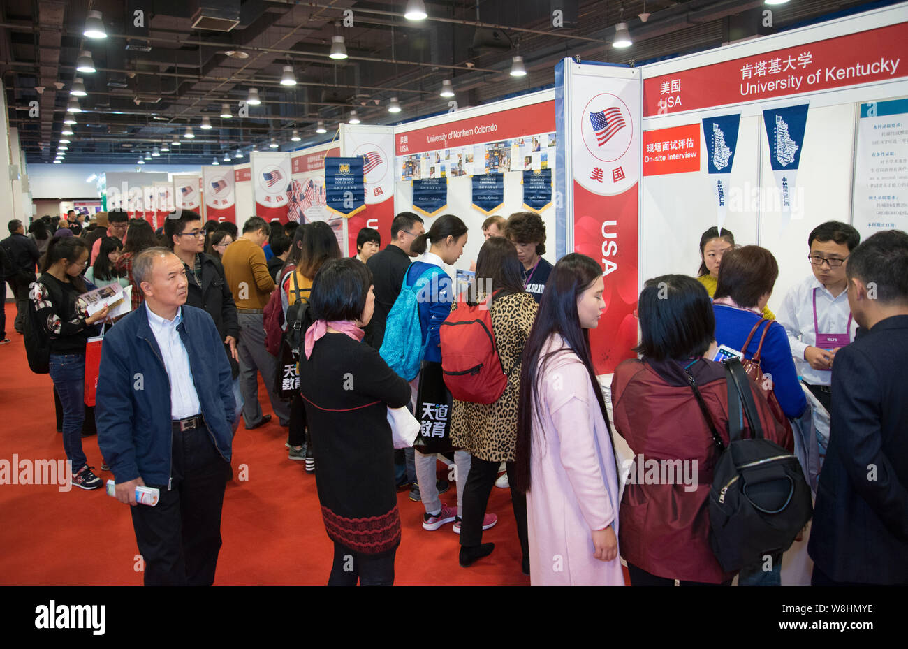 --FILE--Chinese visitors talk with education consultants at the stands of University of Kentucky, University of Northern Colorado and other American u Stock Photo