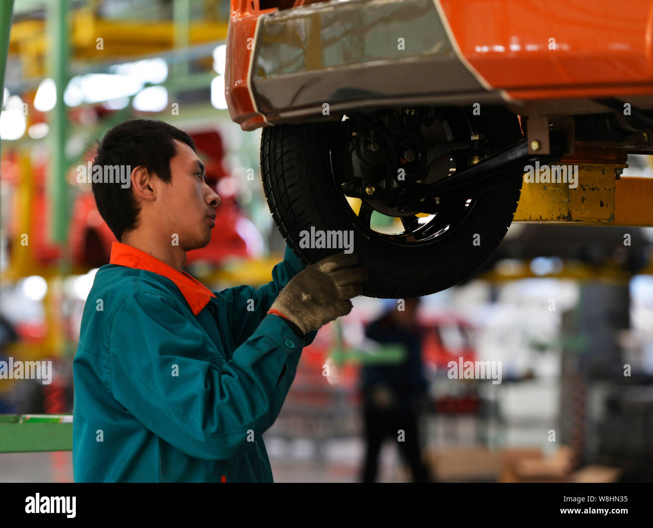 --FILE--A Chinese worker assembles a car on the assembly line at an ...