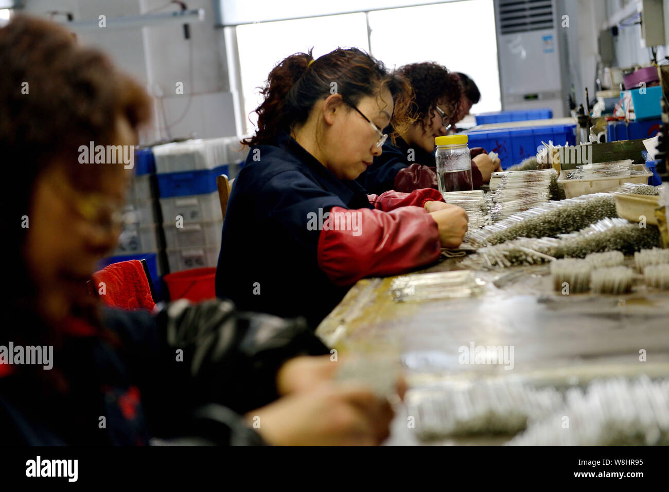 Chinese workers check mercury-in-glass thermometers at the plant of Jiangsu Yuyue Medical Equipment & Supply Co., Ltd. in Yancheng city, east China's Stock Photo
