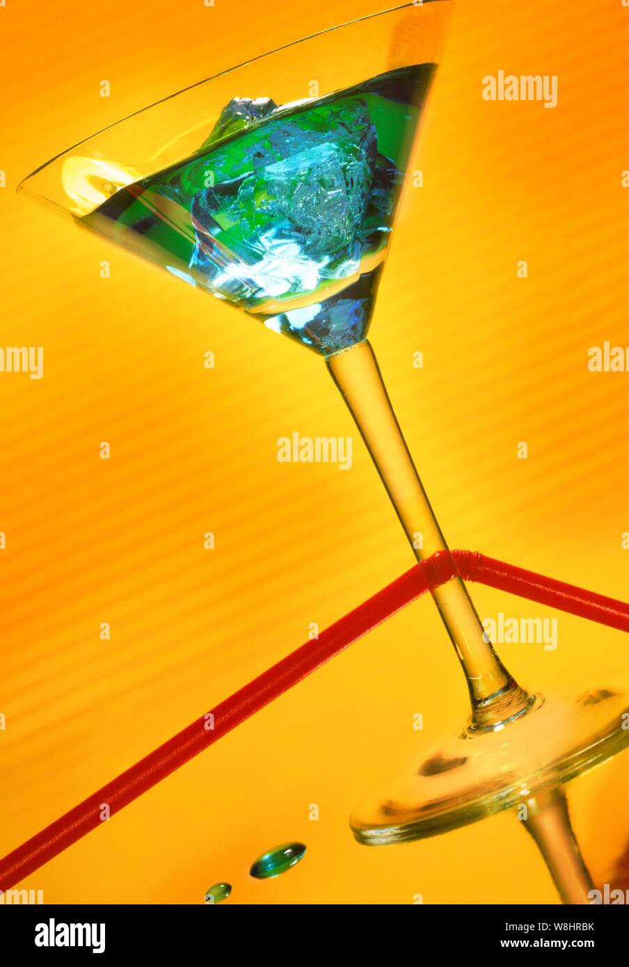 Cocktail glass against yellow background. Stock Photo