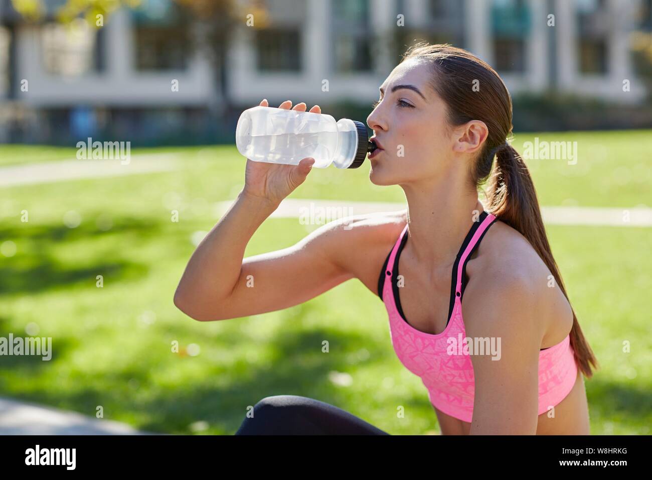 Young woman drinking from a water bottle. Stock Photo