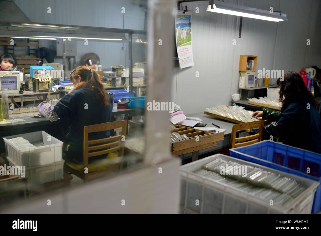 Chinese workers manufacture mercury-in-glass thermometers at the plant of Jiangsu Yuyue Medical Equipment & Supply Co., Ltd. in Yancheng city, east Ch Stock Photo