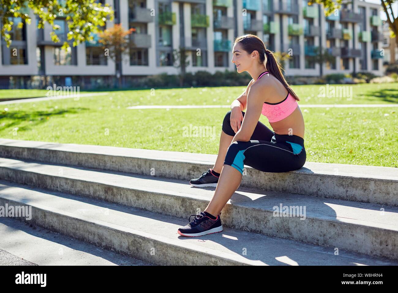 Young woman sitting on steps, resting. Stock Photo