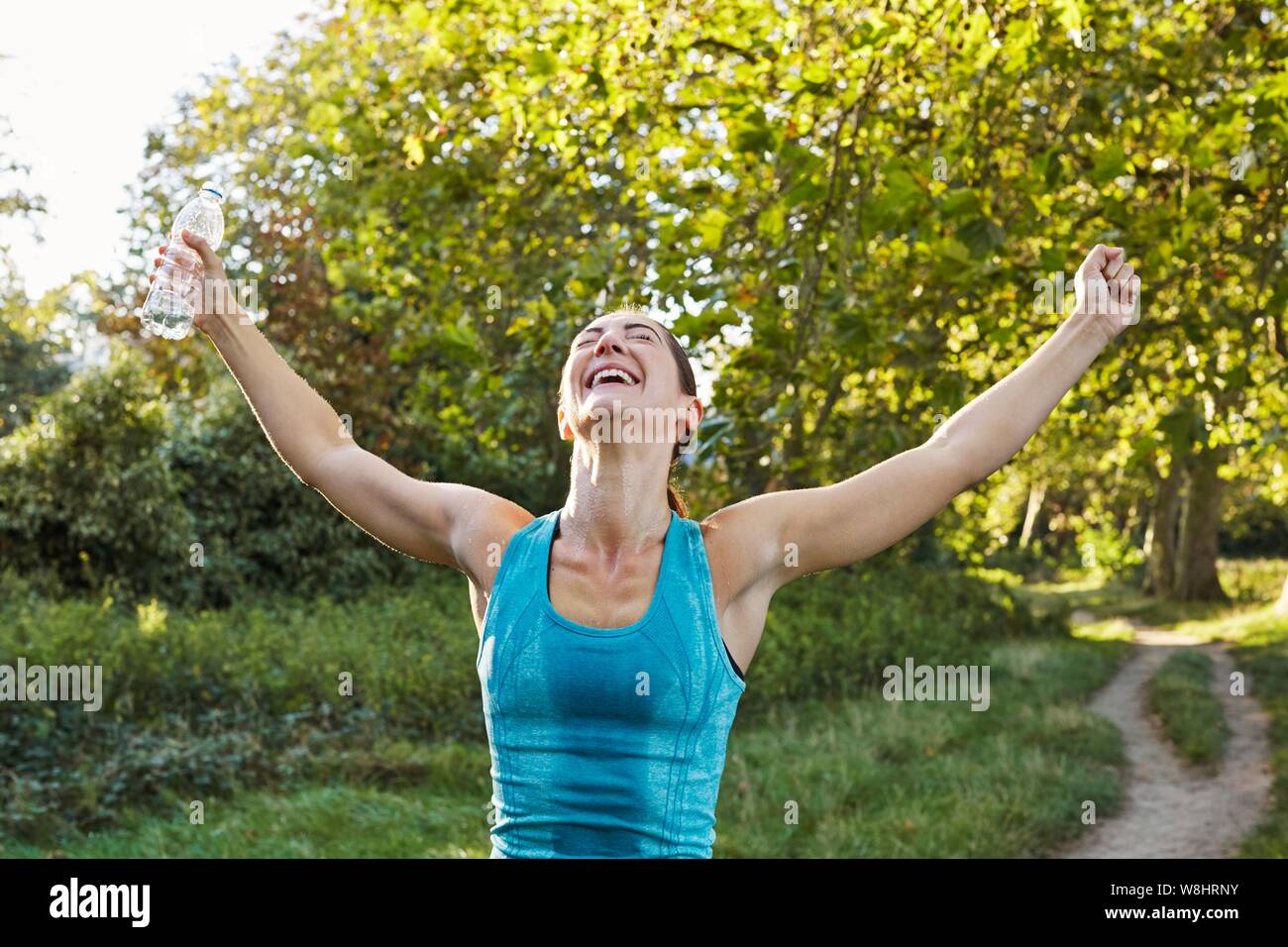 Young woman cheering with her arms out. Stock Photo