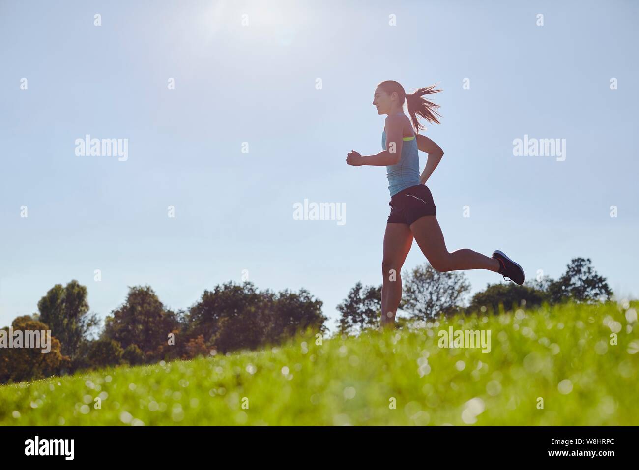 Young woman jogging in a field. Stock Photo