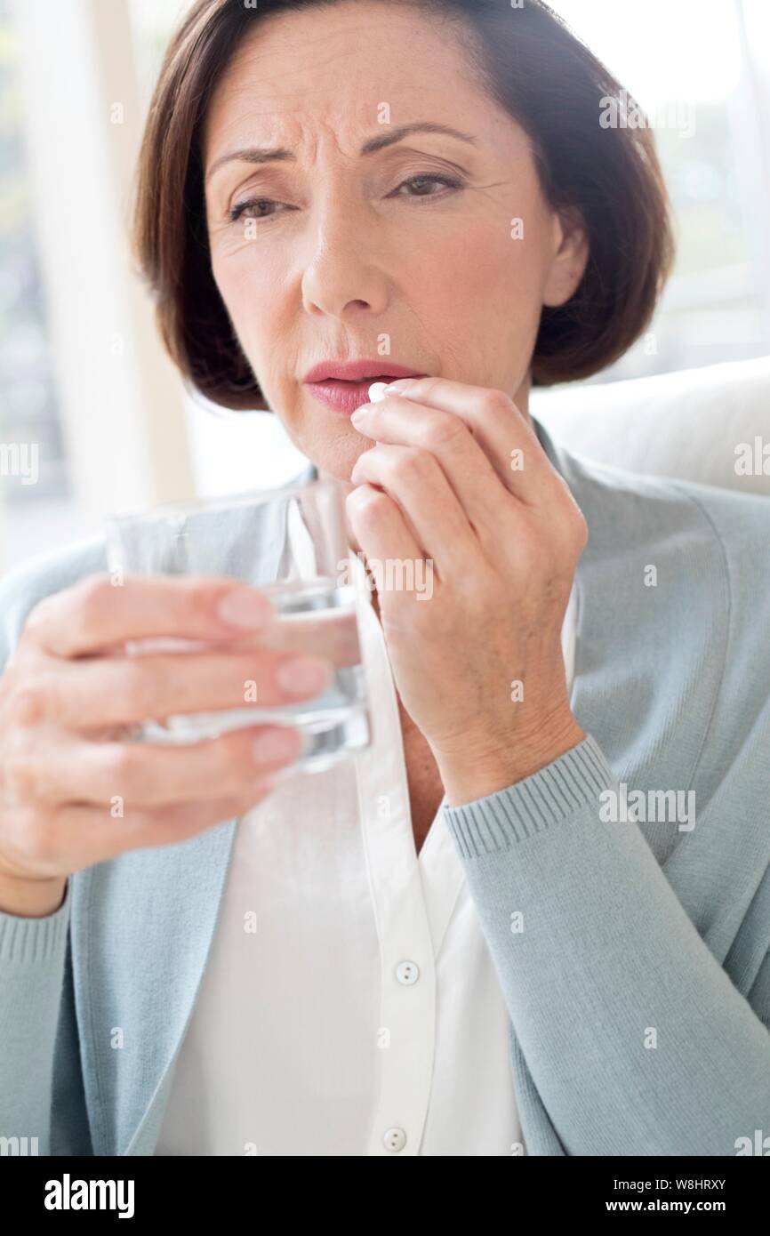 Mature woman taking tablet. Stock Photo