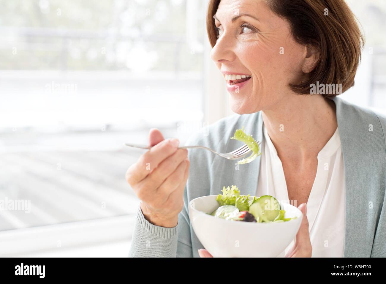 Mature woman eating salad. Stock Photo