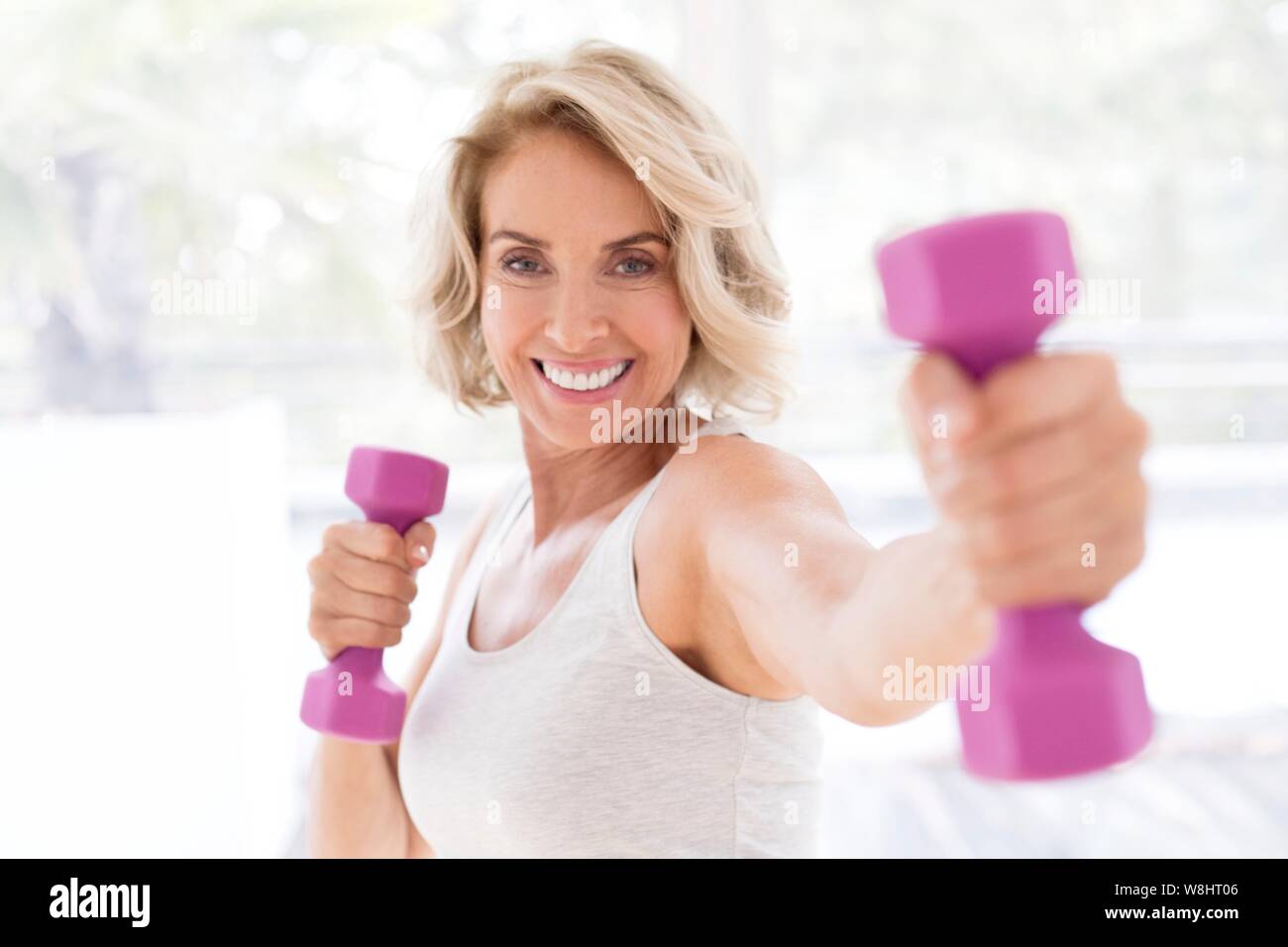 Mature woman using hand weights. Stock Photo