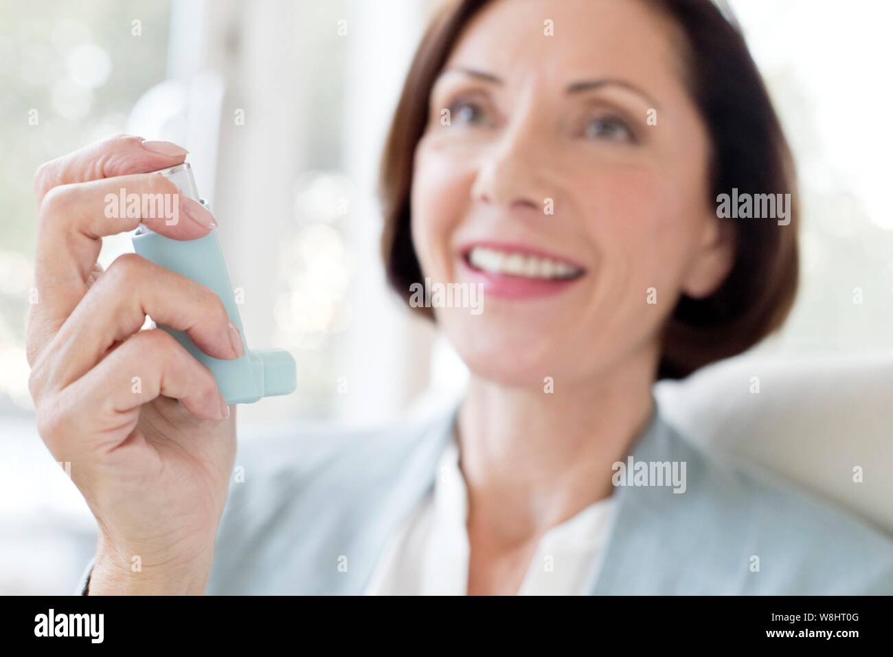 Mature woman using inhaler. Stock Photo