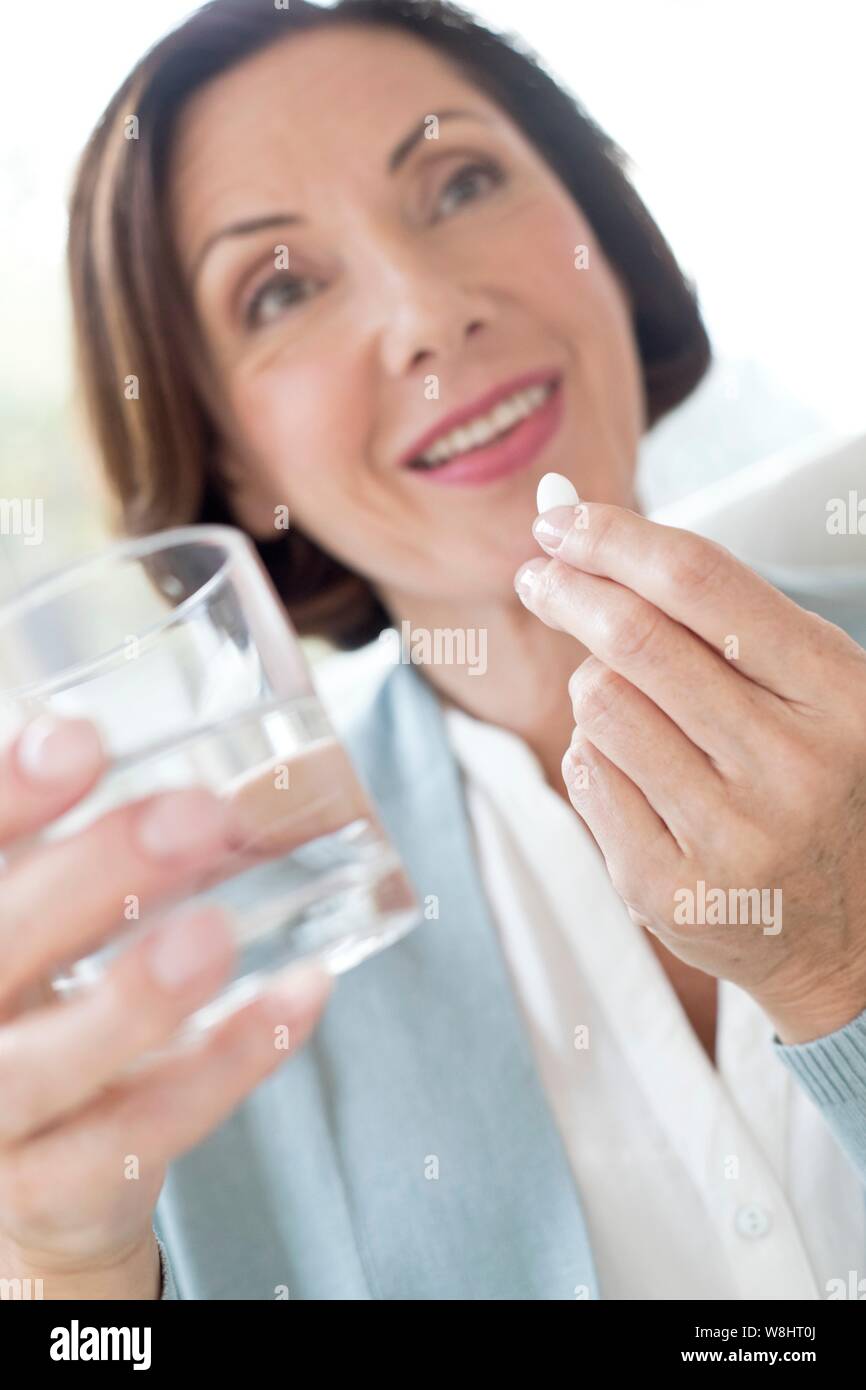 Mature woman taking tablet. Stock Photo