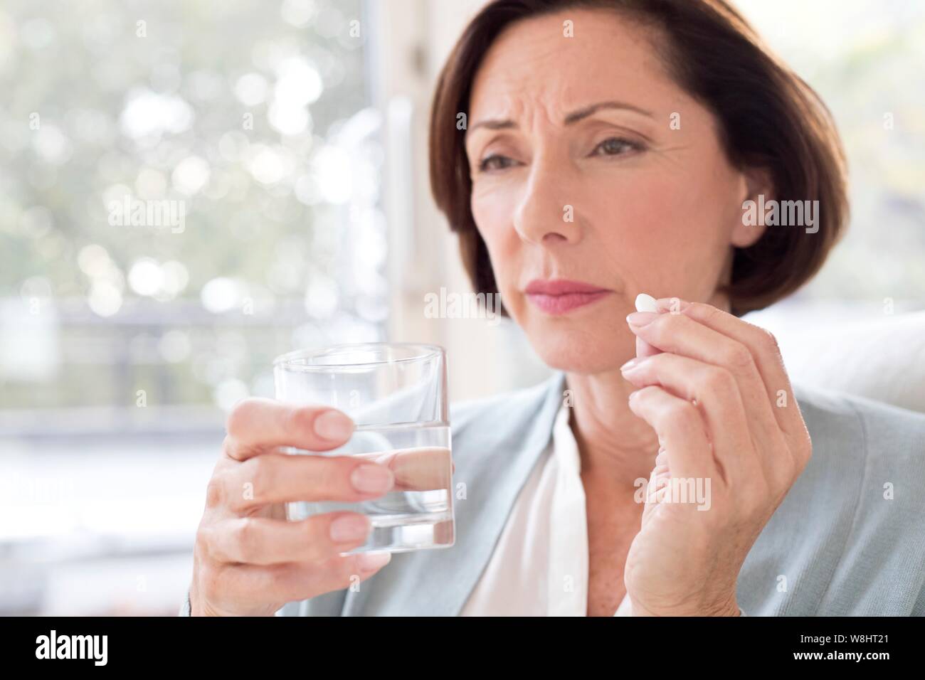 Mature woman taking tablet. Stock Photo