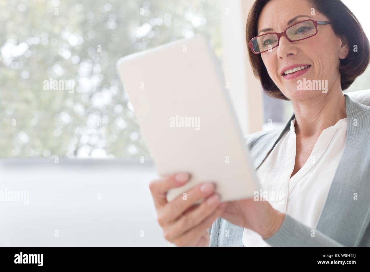 Mature woman using digital tablet. Stock Photo