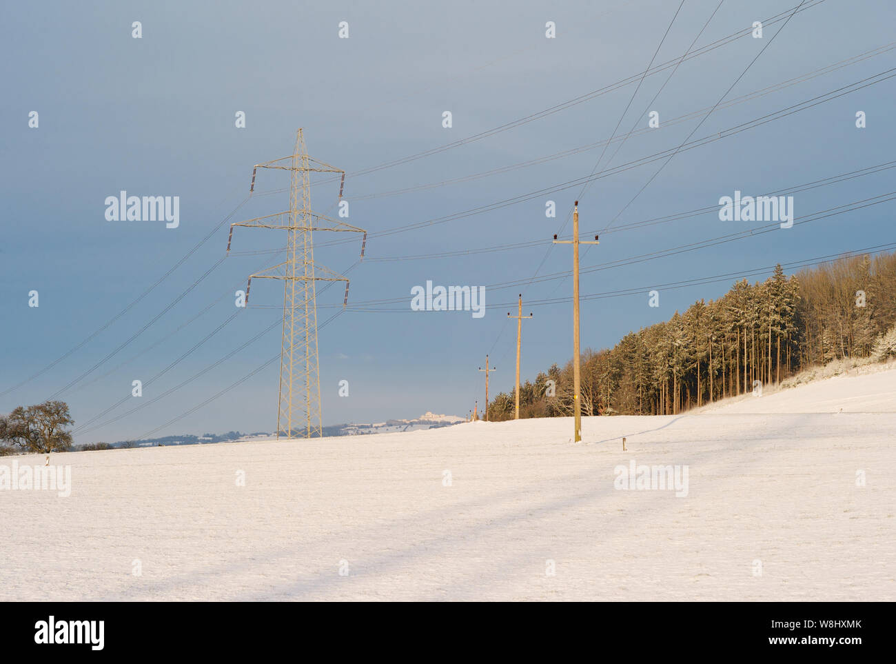 Electric Powerlines Crossing in a Winter Landscape - 20kV - Powerline crossing under a 380kV - Powerline - A Concept for the Transmission of Electic Energy Stock Photo