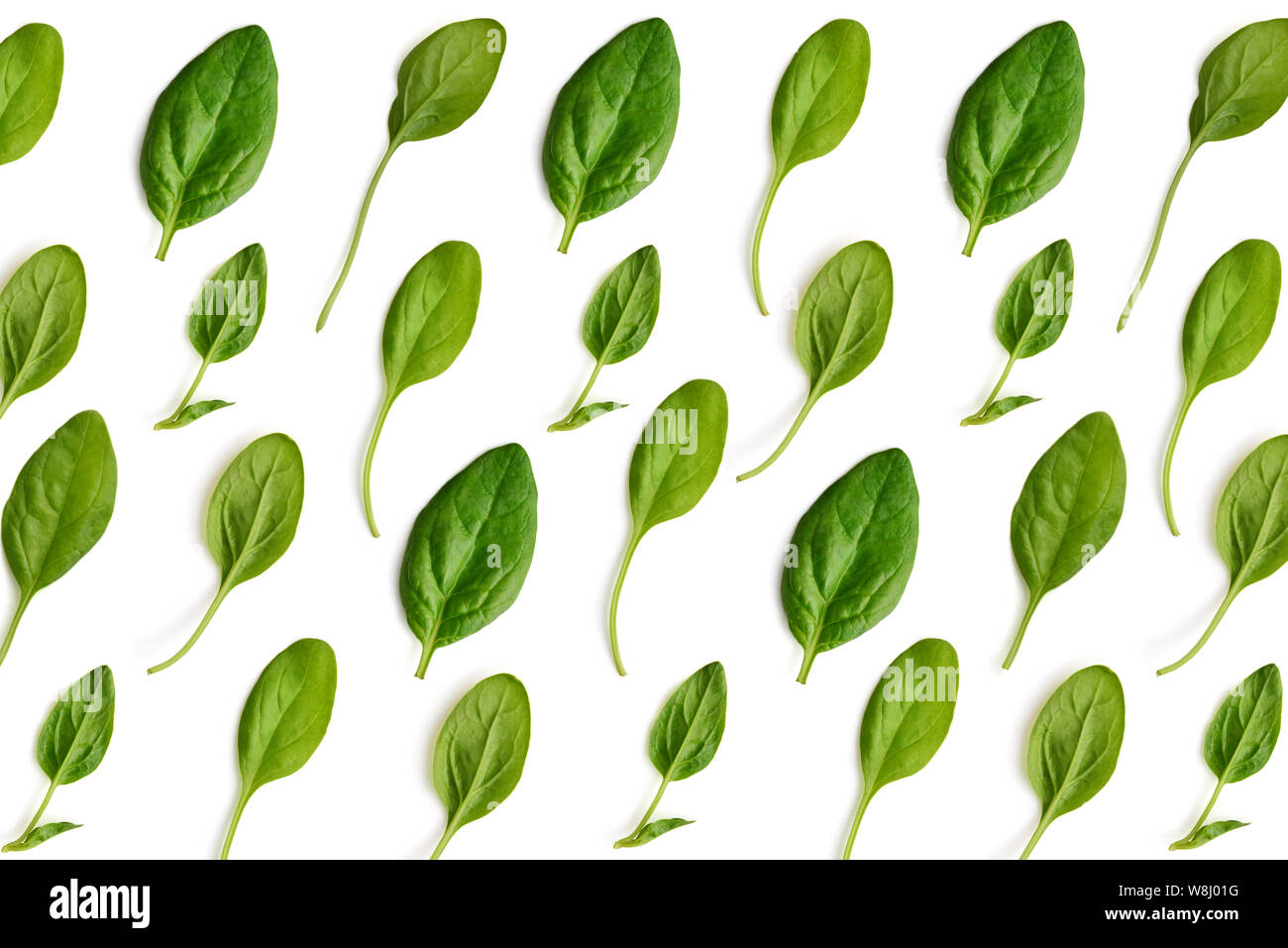 Spinach leaves on white background. Pattern made of spinach. Flat lay, top view Stock Photo