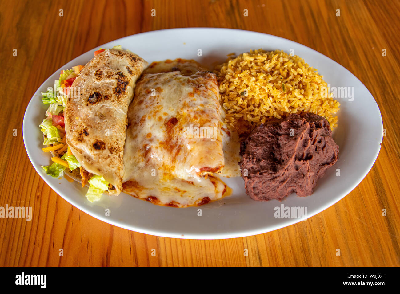 Chicken Enchilada plate with rice, beans and chicken taco Stock Photo