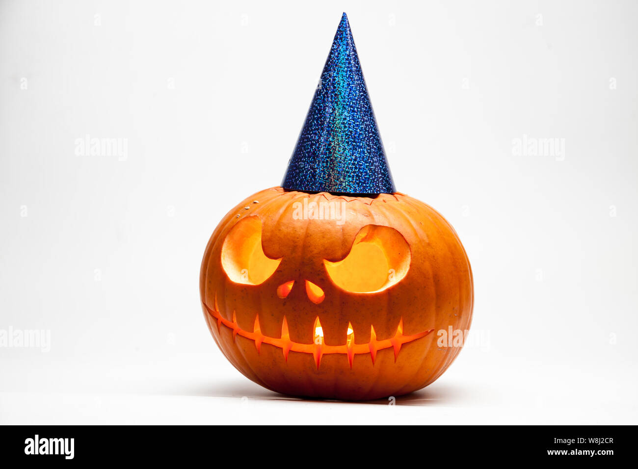 Halloween pumpkin head jack lantern with burning candles with festive hubcap isolated on white background Stock Photo