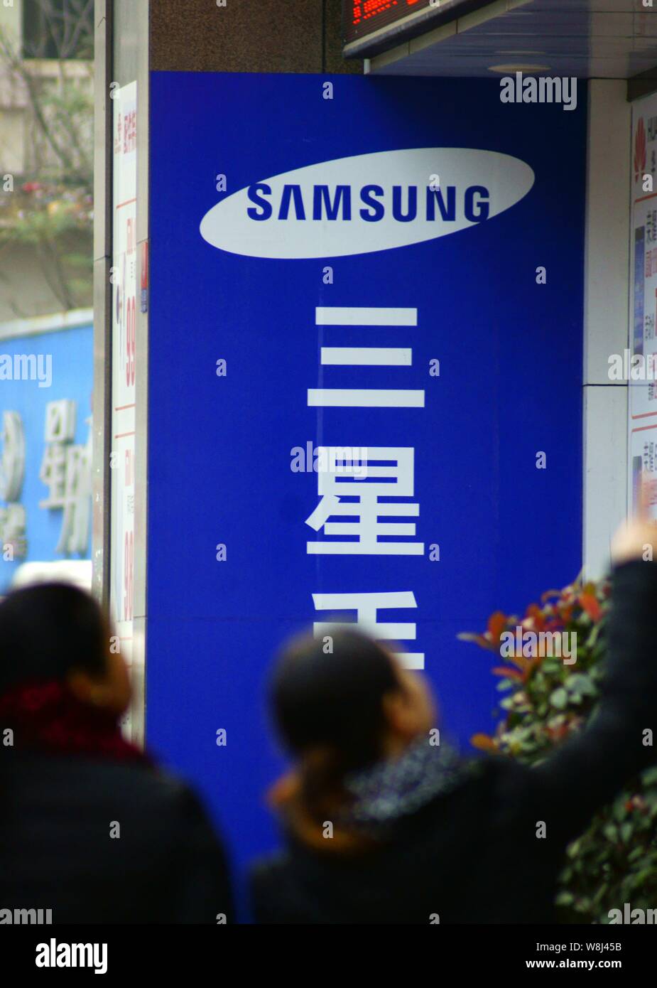 --FILE--Pedestrians walk past a store of Samsung in Yichang city, central China's Hubei province, 7 January 2015.   Foreign investment into China acce Stock Photo