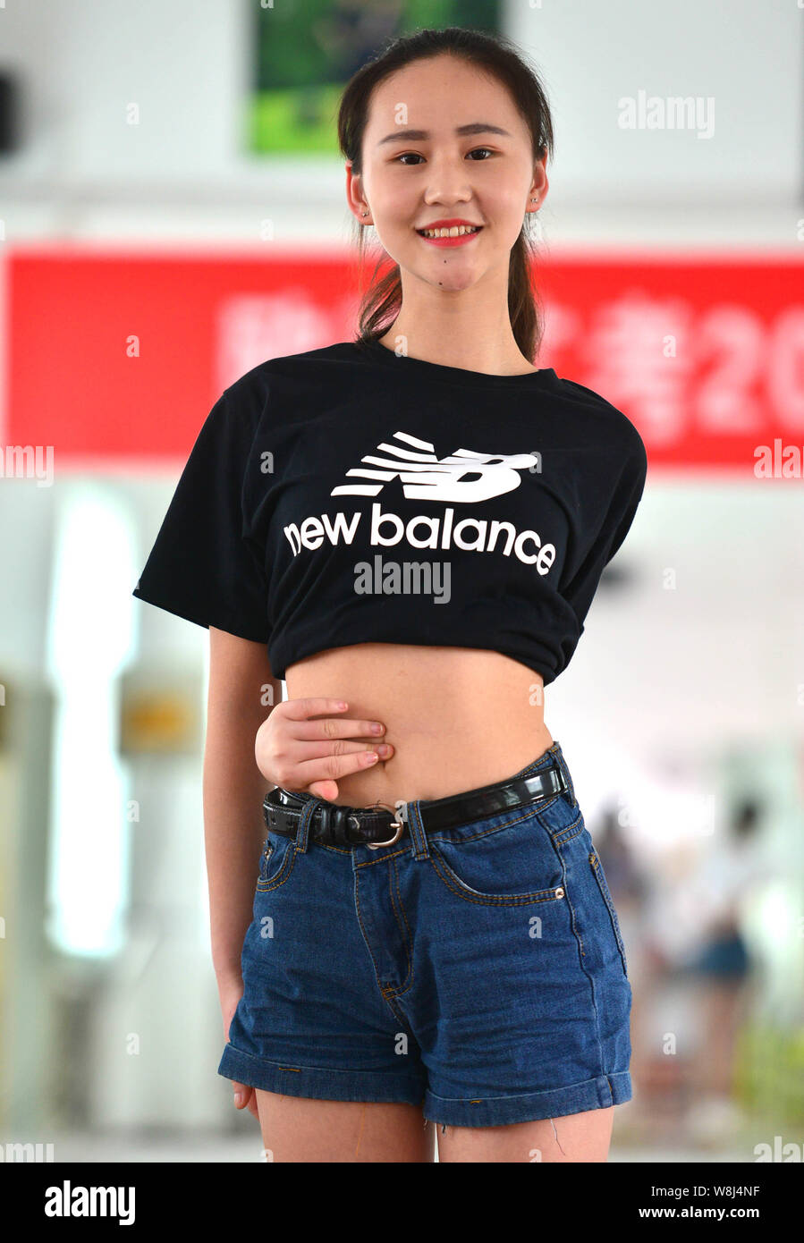 A Chinese student wraps her arm around her waist and touches her  belly-button to attempt a Belly-button challenge at a school in Luoyang  city, centr Stock Photo - Alamy
