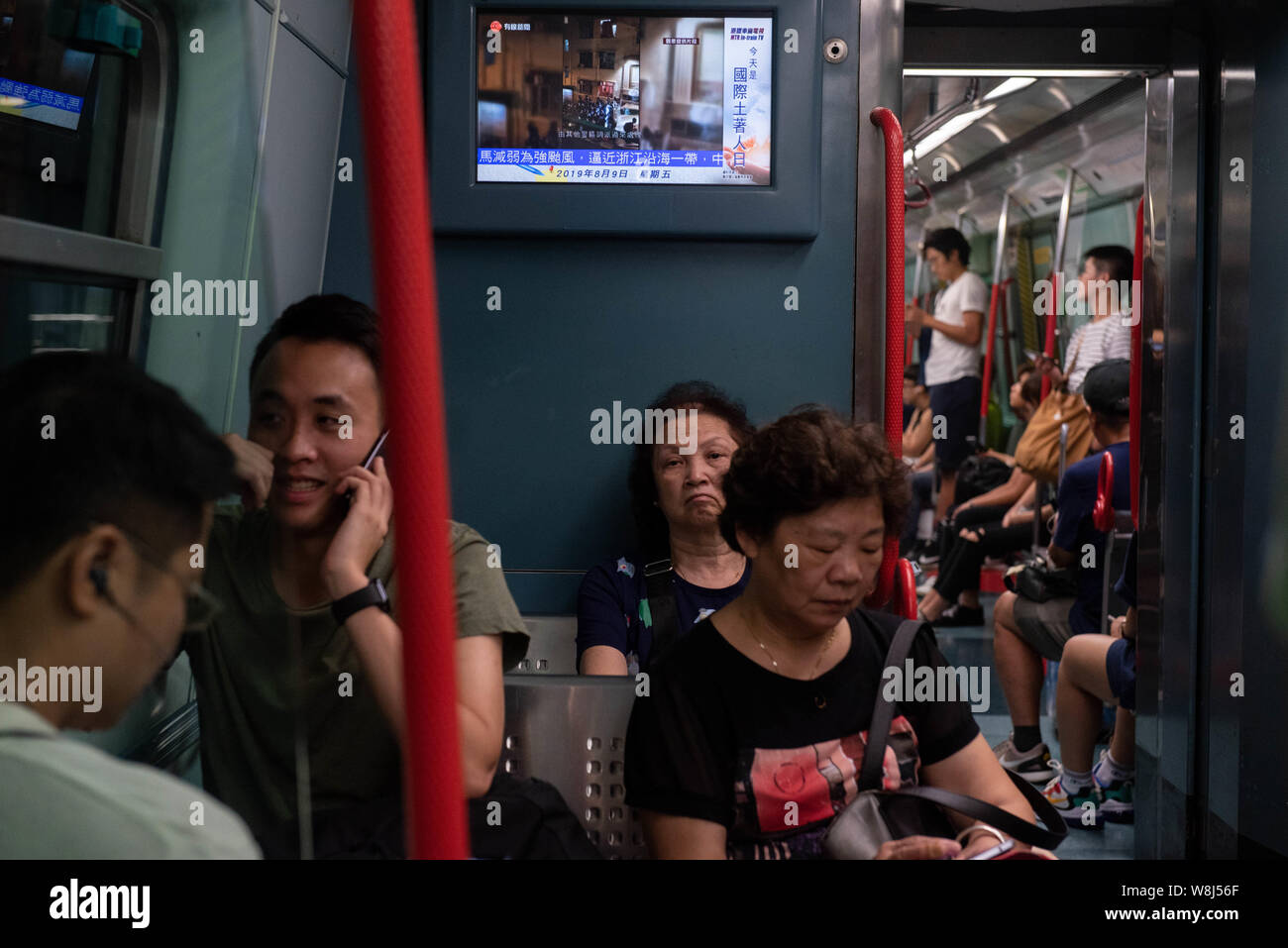 Commuters Ride Hong Kong S Mtr Subway Train While Political And Protest Related News Are Shown Above Them On Tv Thousands Of Anti Government Protesters Took To The Street Of Hong Kong Once Again