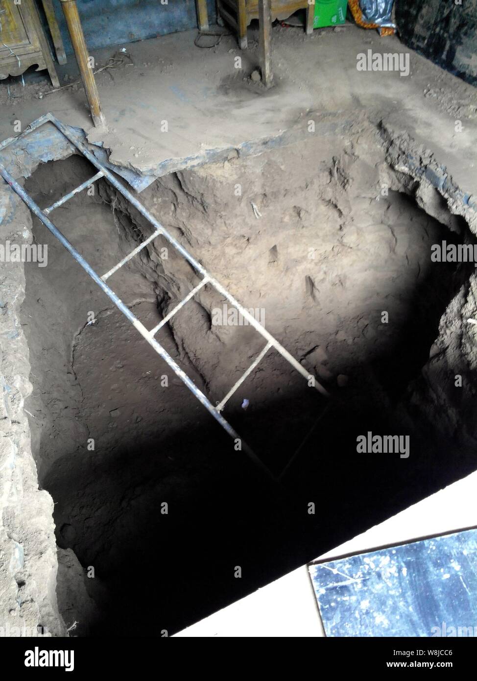 View of the 3-meter hole which a man dug in his living room to unearth a deposit passbook that his wife hid underneath the living room floor before sh Stock Photo