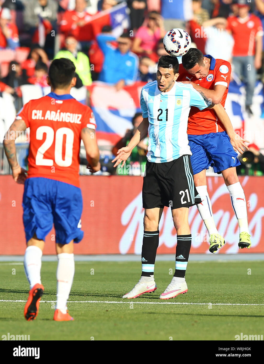 Argentina's Javier Pastore, center, and Chile's Mauricio Isla, right, head the ball during the Copa America 2015 final soccer match between Chile and Stock Photo