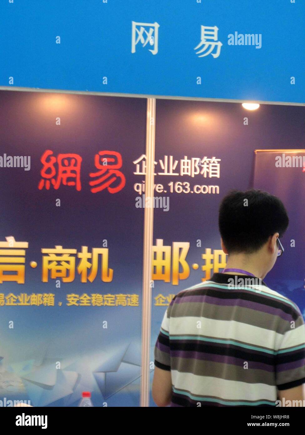 --FILE--A visitor walks past the stand of NetEase, also known as 163 ...