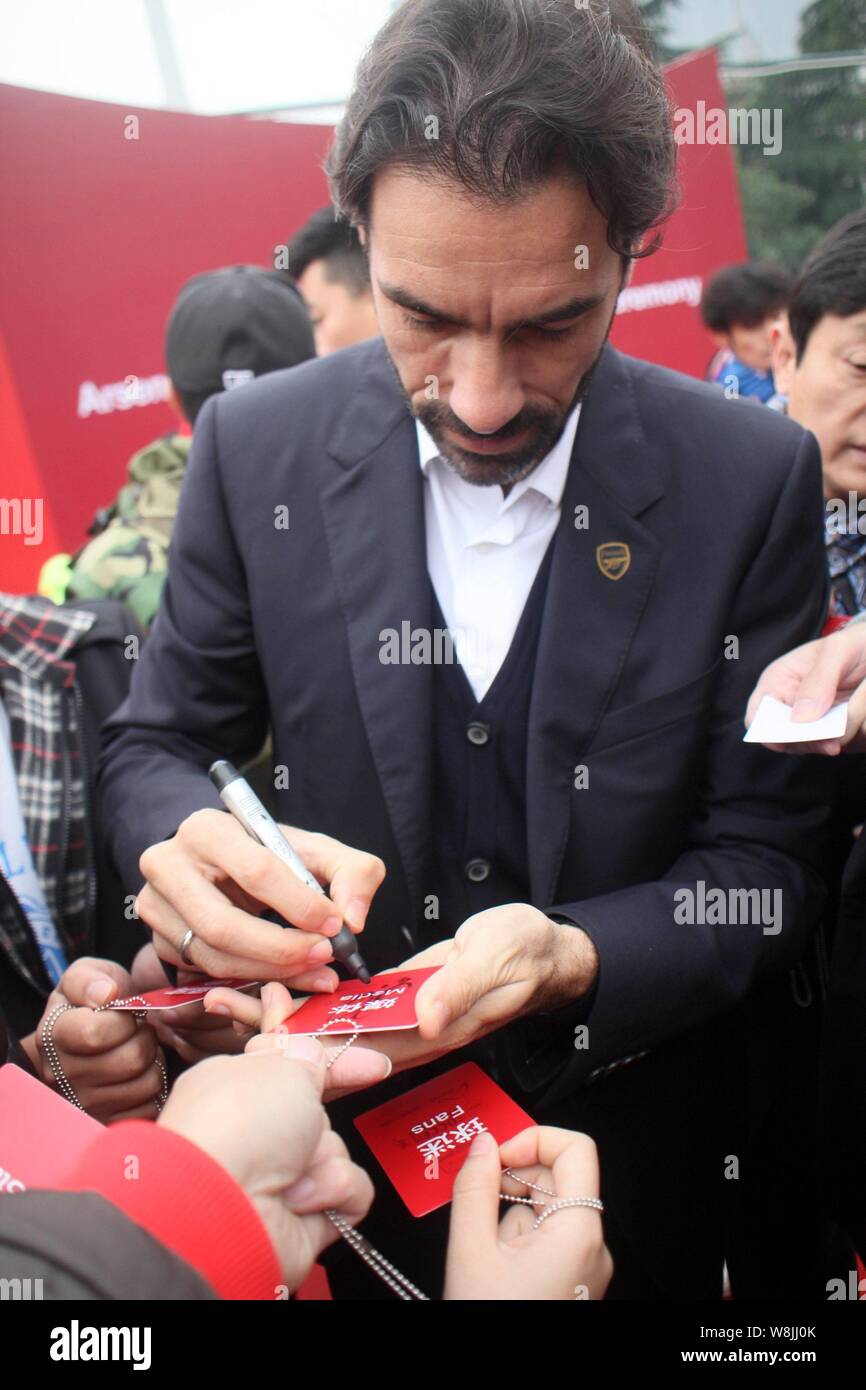 Retired French football player Robert Pires signs an autograph for a fan during the opening ceremony of the Arsenal Soccer School (China) in Shanghai, Stock Photo