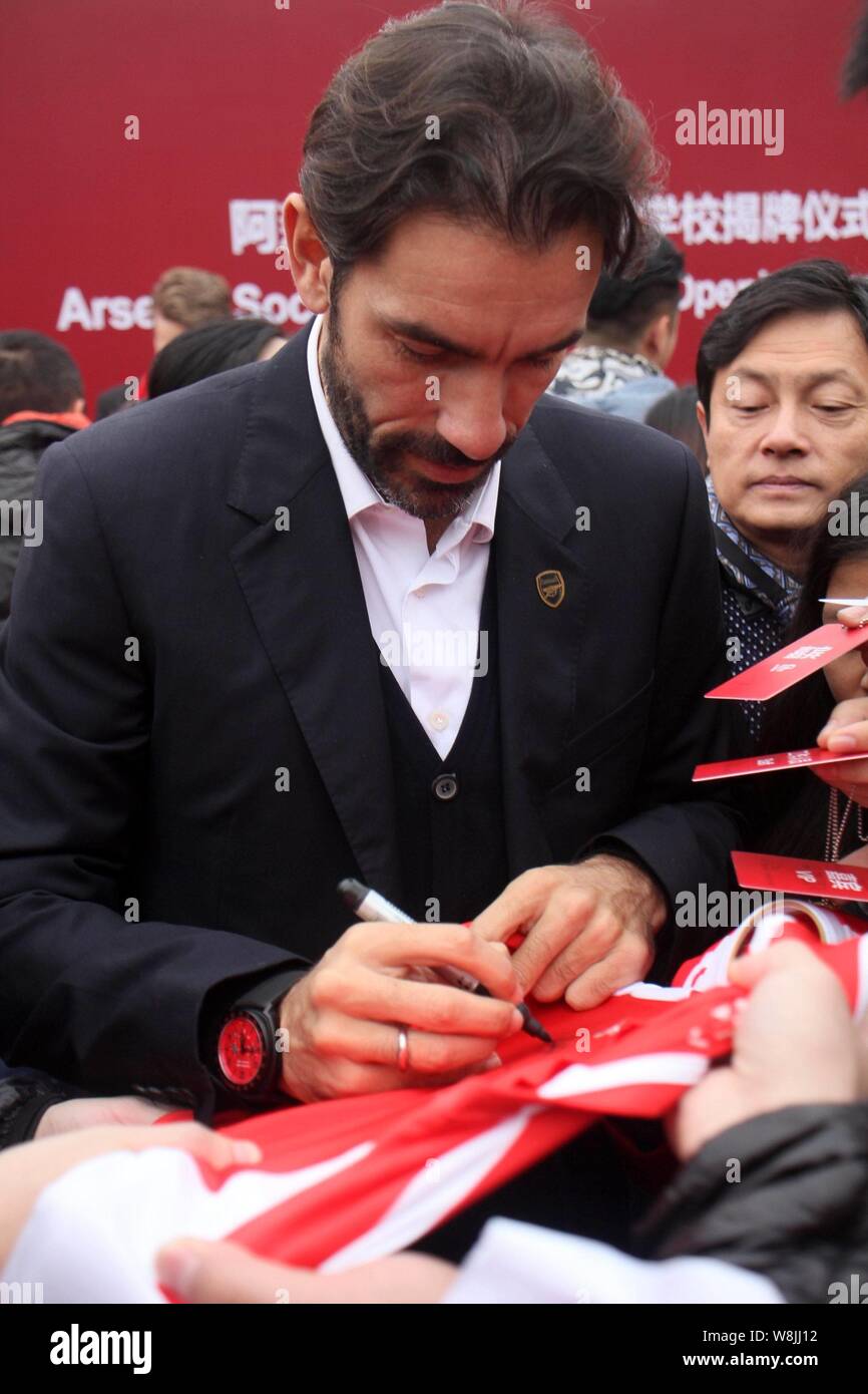 Retired French football player Robert Pires signs an autograph for a fan during the opening ceremony of the Arsenal Soccer School (China) in Shanghai, Stock Photo