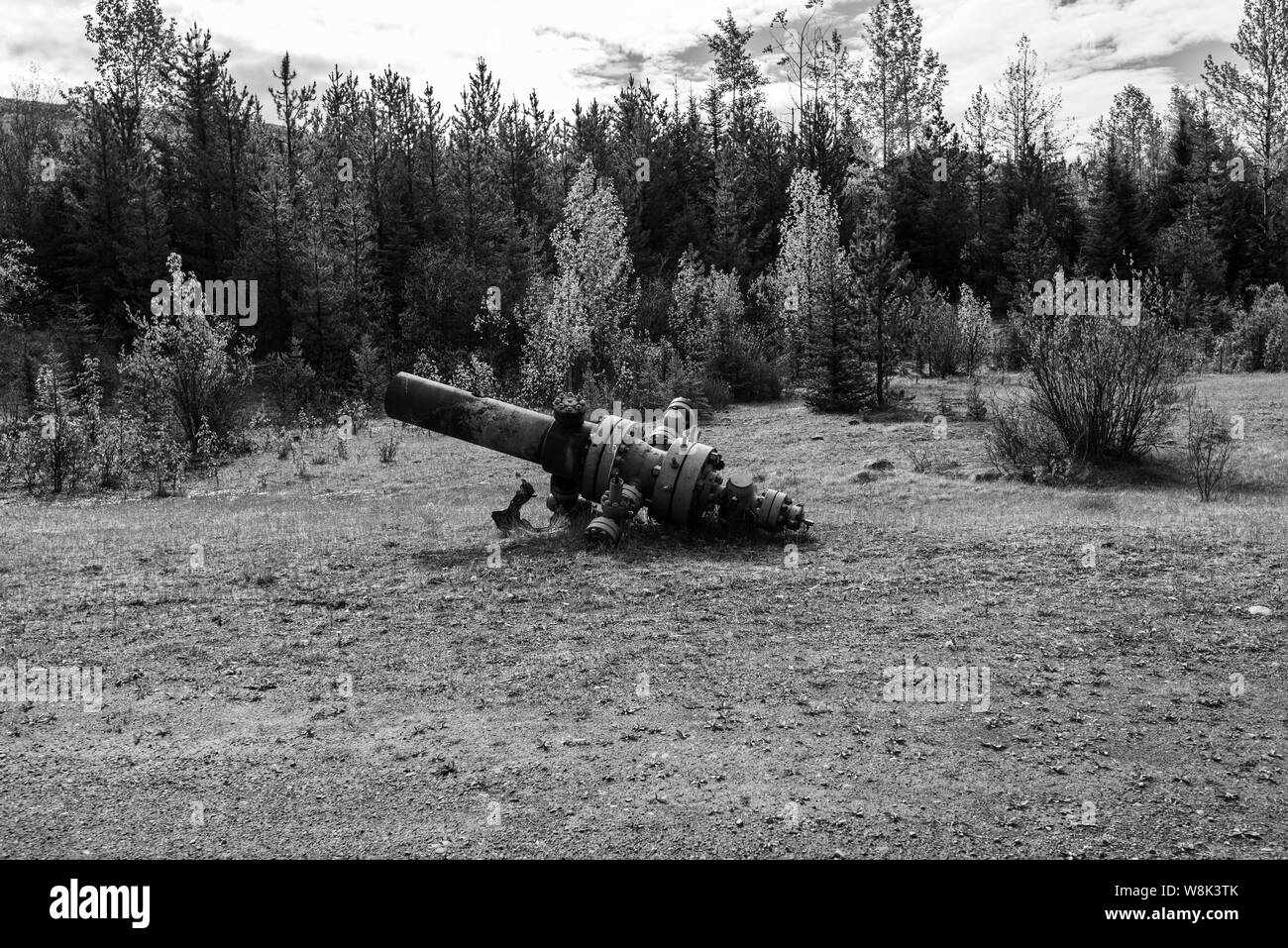 An oil and gas well head left on the side of a road in the beautiful wilderness Stock Photo