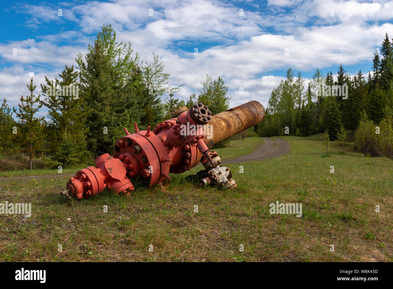 An oil and gas well head left on the side of a road in the beautiful wilderness Stock Photo