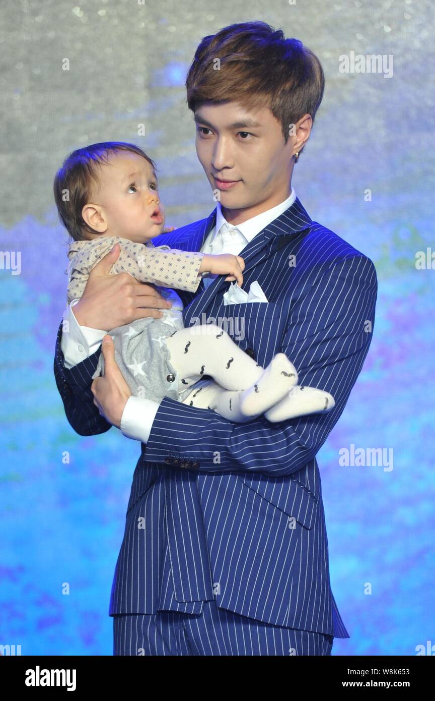 Chinese actor Zhang Yixing poses with a little baby at a press