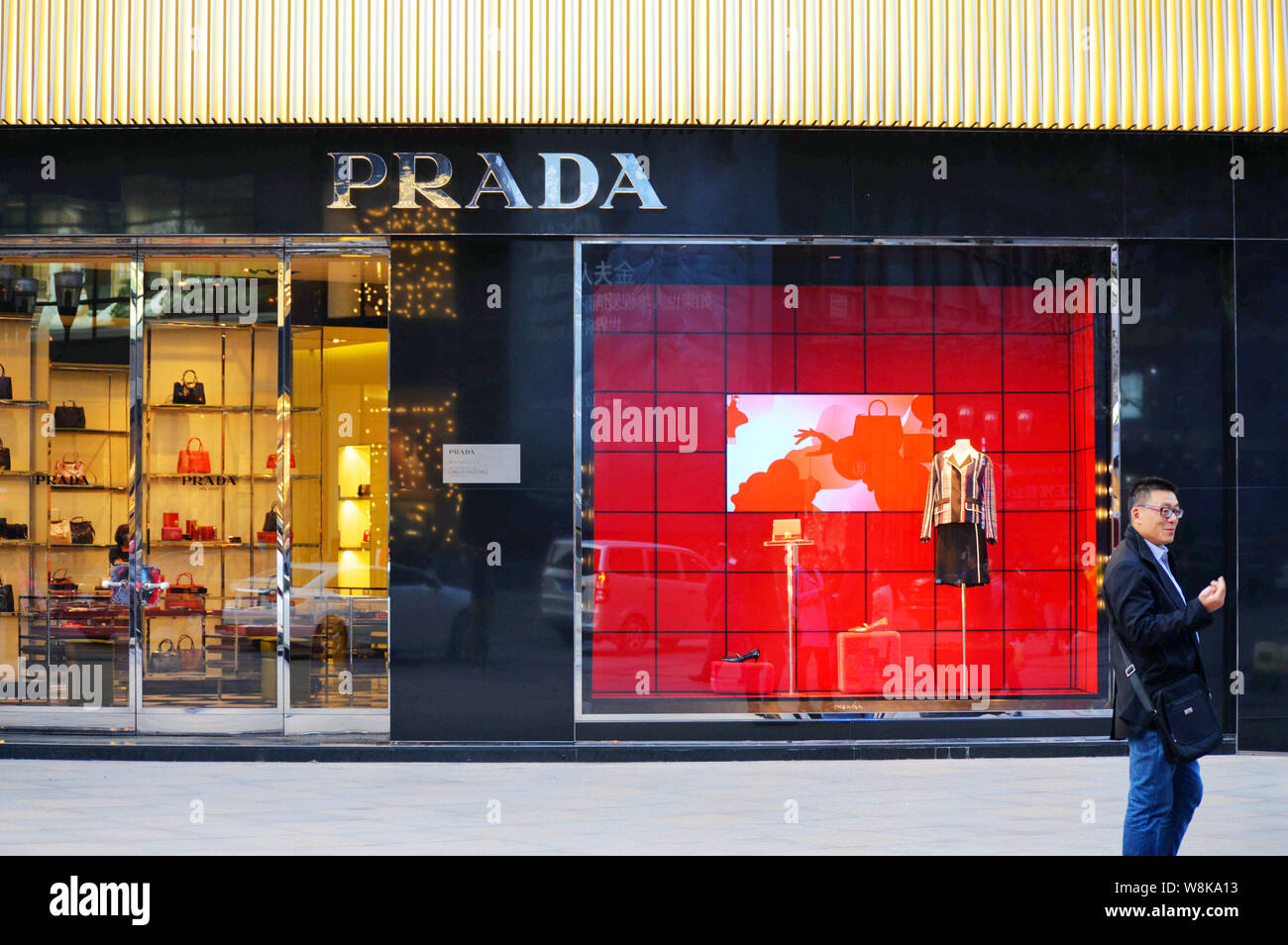 FILE--A pedestrian walks past a fashion boutique of Prada in Chongqing, 27  February 2016. Fashion brands from South Korea, China and Japan are bec  Stock Photo - Alamy