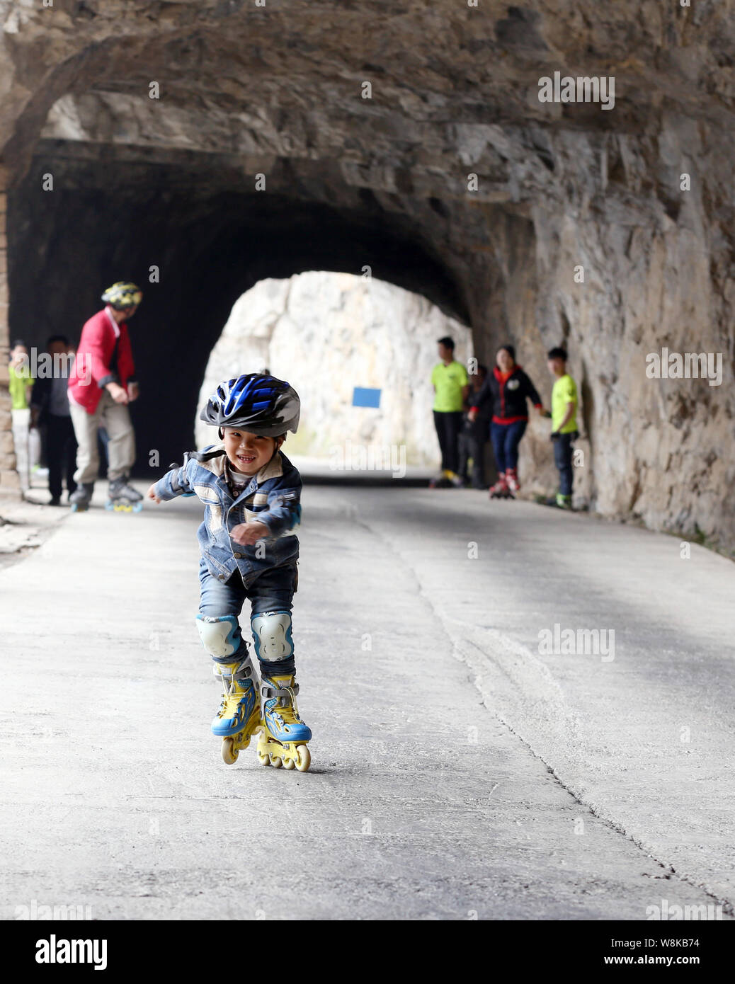 Four-year-old boy Zhang Jiabo roller-skates in a tunnel on the cliff of a mountain during a roller skating challenge to mark the World Earth Day in th Stock Photo
