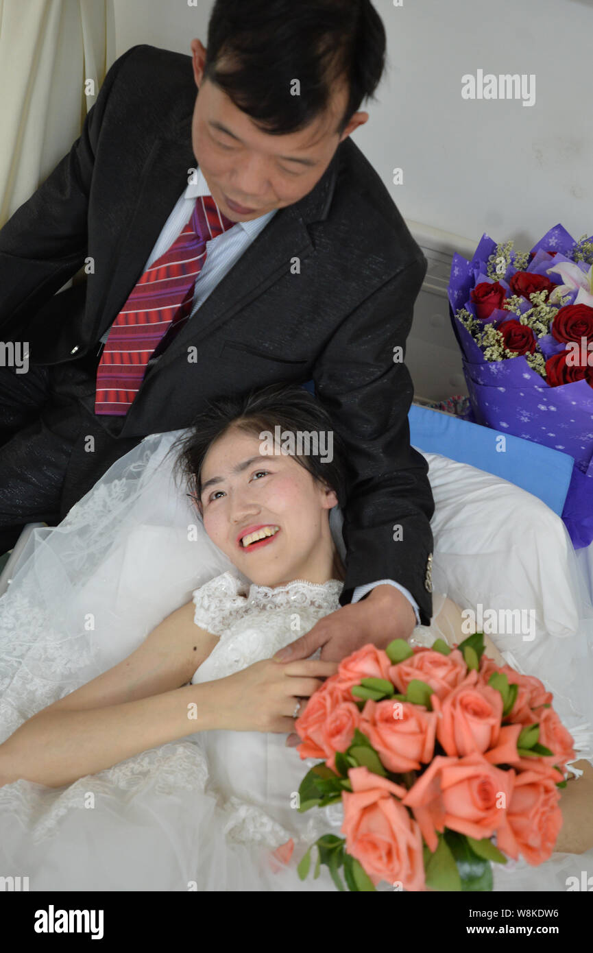 Terminally ill Chinese woman Yang Liu dressed in a wedding gown, right, holds her husband Peng Xin during their wedding ceremony in a ward at a hospit Stock Photo