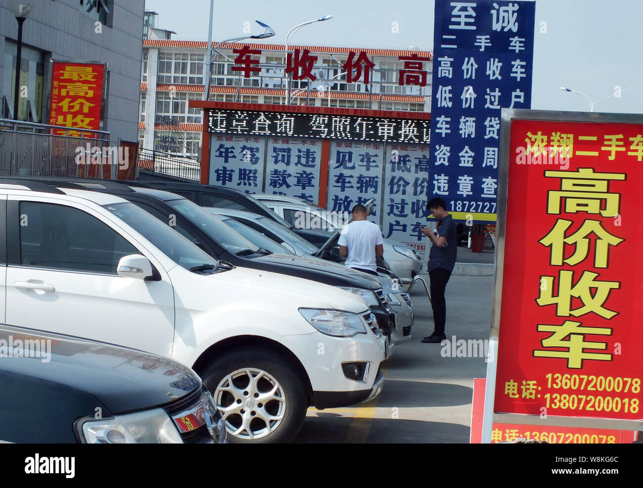 --FILE--Chinese buyers look at second-hand cars at a used car market in Yichang city, central Chna's Hubei province, 11 August 2015.   China aims to t Stock Photo