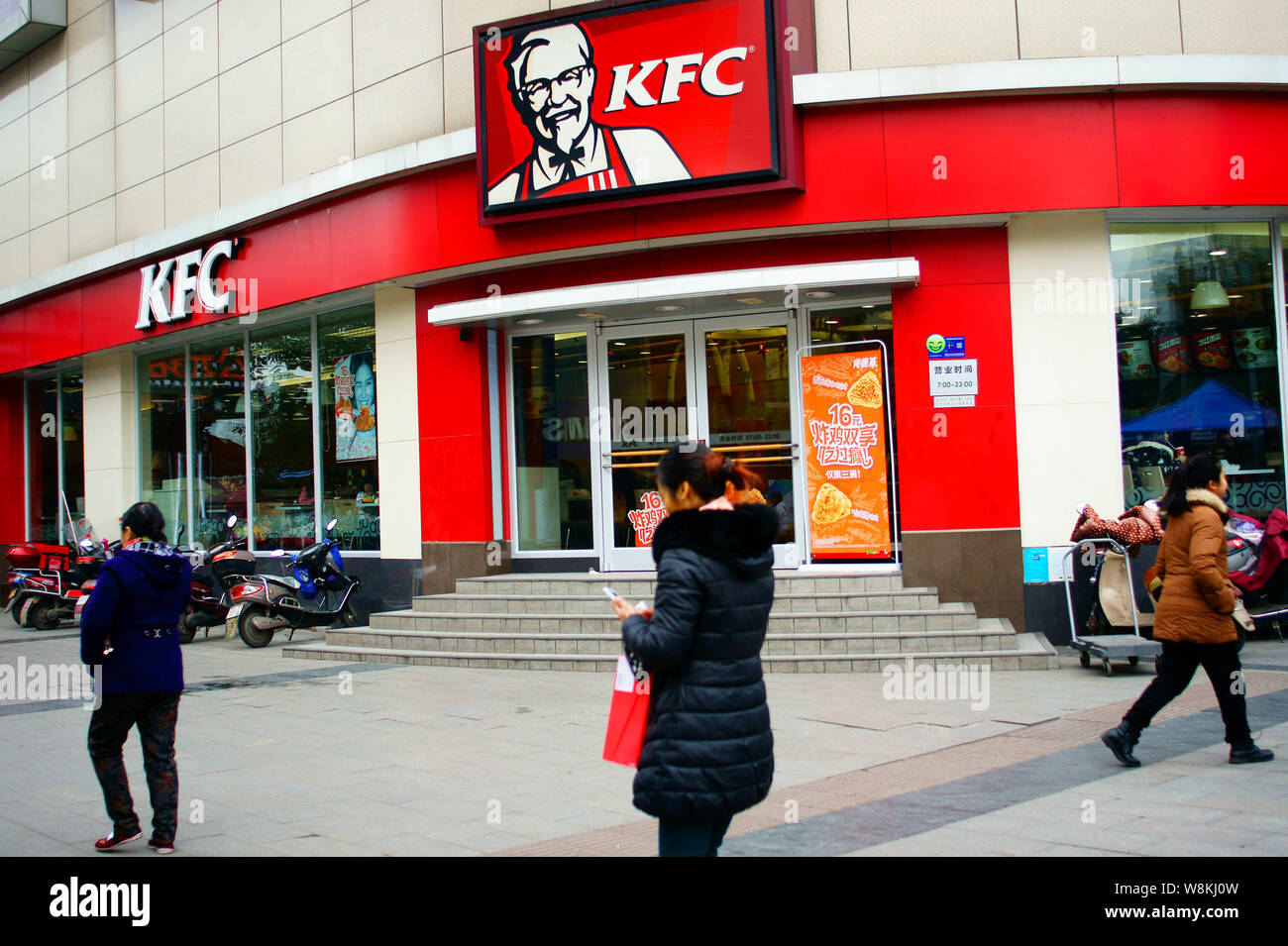 File Pedestrians Walk Past A Fastfood Restaurant Of Kfc In Yichang City Central Chinas Hubei Province 13 January 2016 One Of Chinas Largest W8KJ0W 