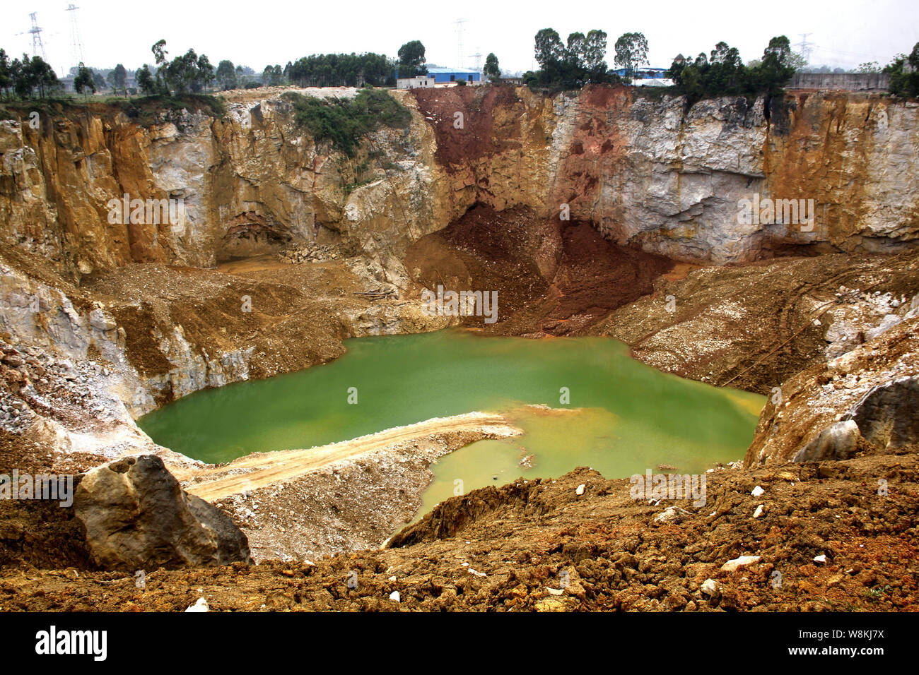 A view of the giant pit at a quarry which is suspected to be a main cause of the drawdown in neighboring fish ponds in Baisha town, Guiping city, sout Stock Photo