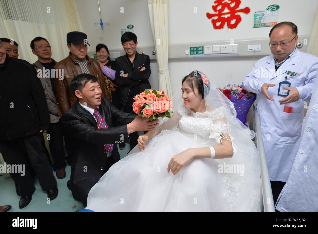 Terminally ill Chinese woman Yang Liu dressed in a wedding gown, second right, receives a wedding proposal from her husband Peng Xin, third right, dur Stock Photo