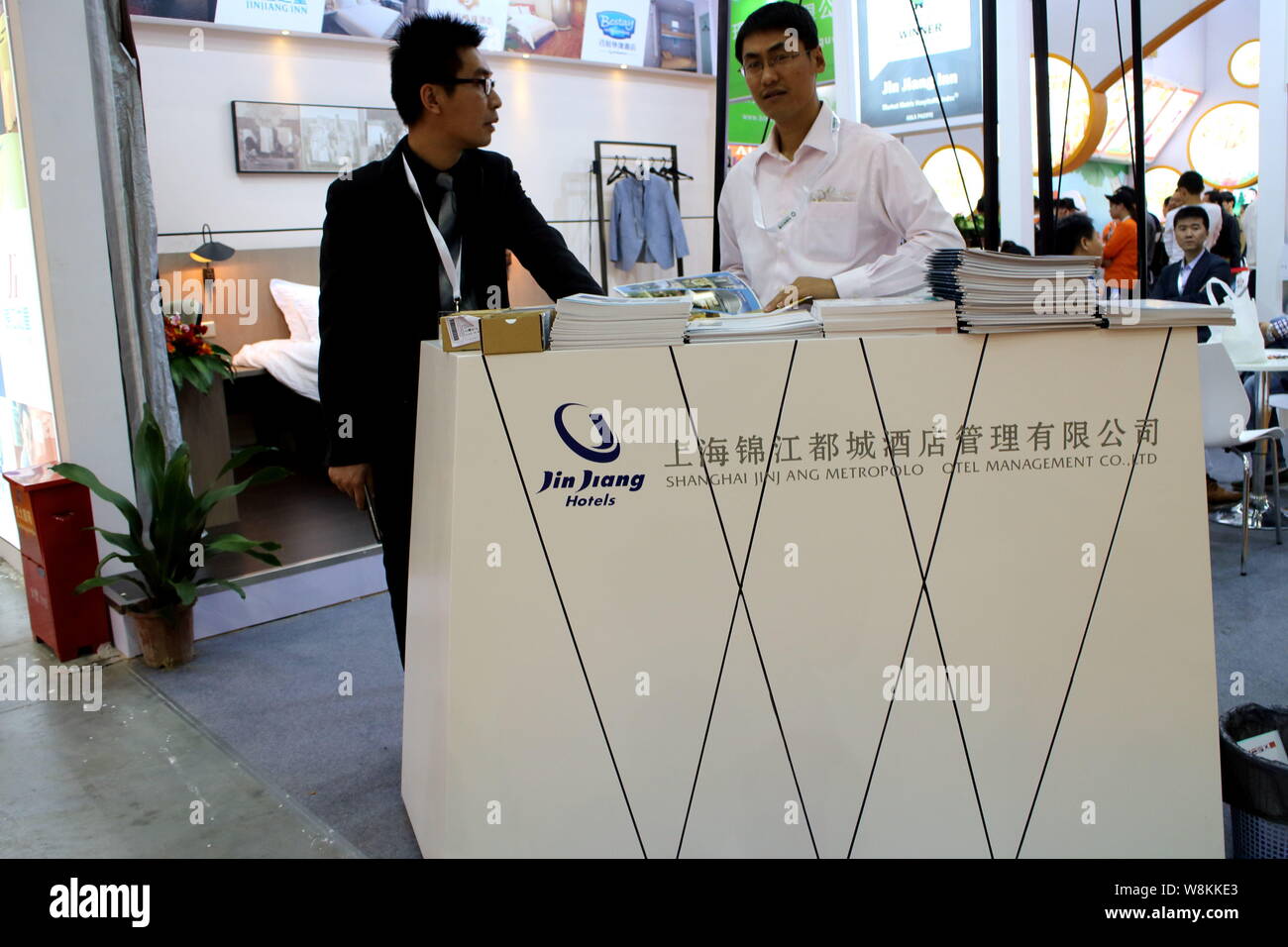 --FILE--Chinese employees are seen at the stand of Jin Jiang Hotels and Shanghai Jin Jiang Metropolo Hotel Management Co., Ltd. during an exhibition i Stock Photo