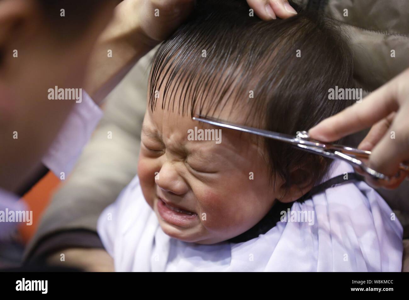 A Young Chinese Boy Weeps While Having His Hair Cut At A Barber S