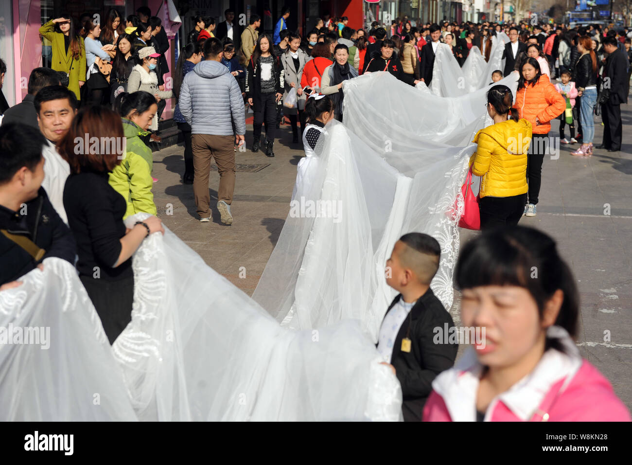Young Kids And Staff Members From A Wedding Dress Company Carry