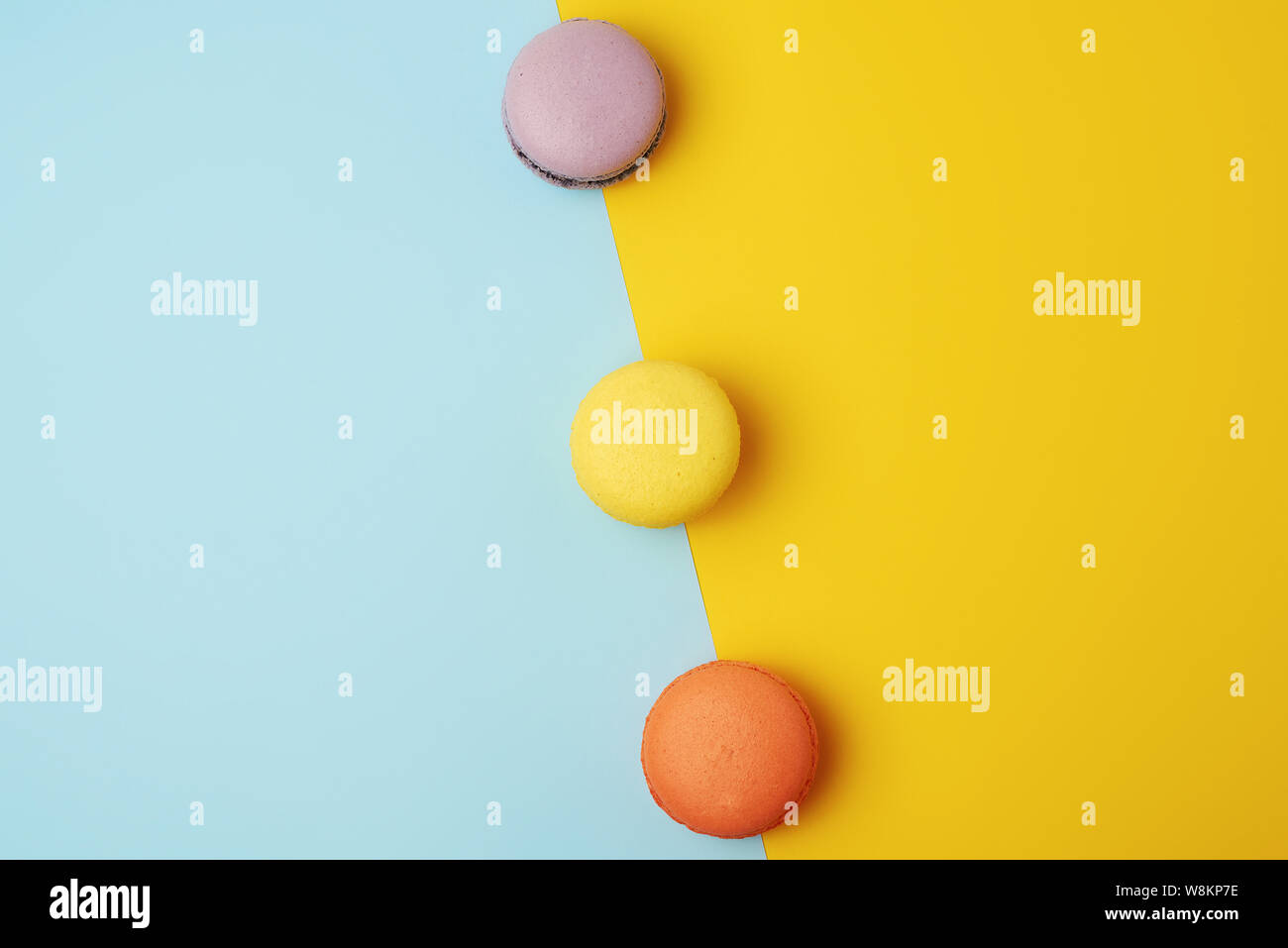 multi-colored baked round macarons on a colored background, flat lay Stock Photo