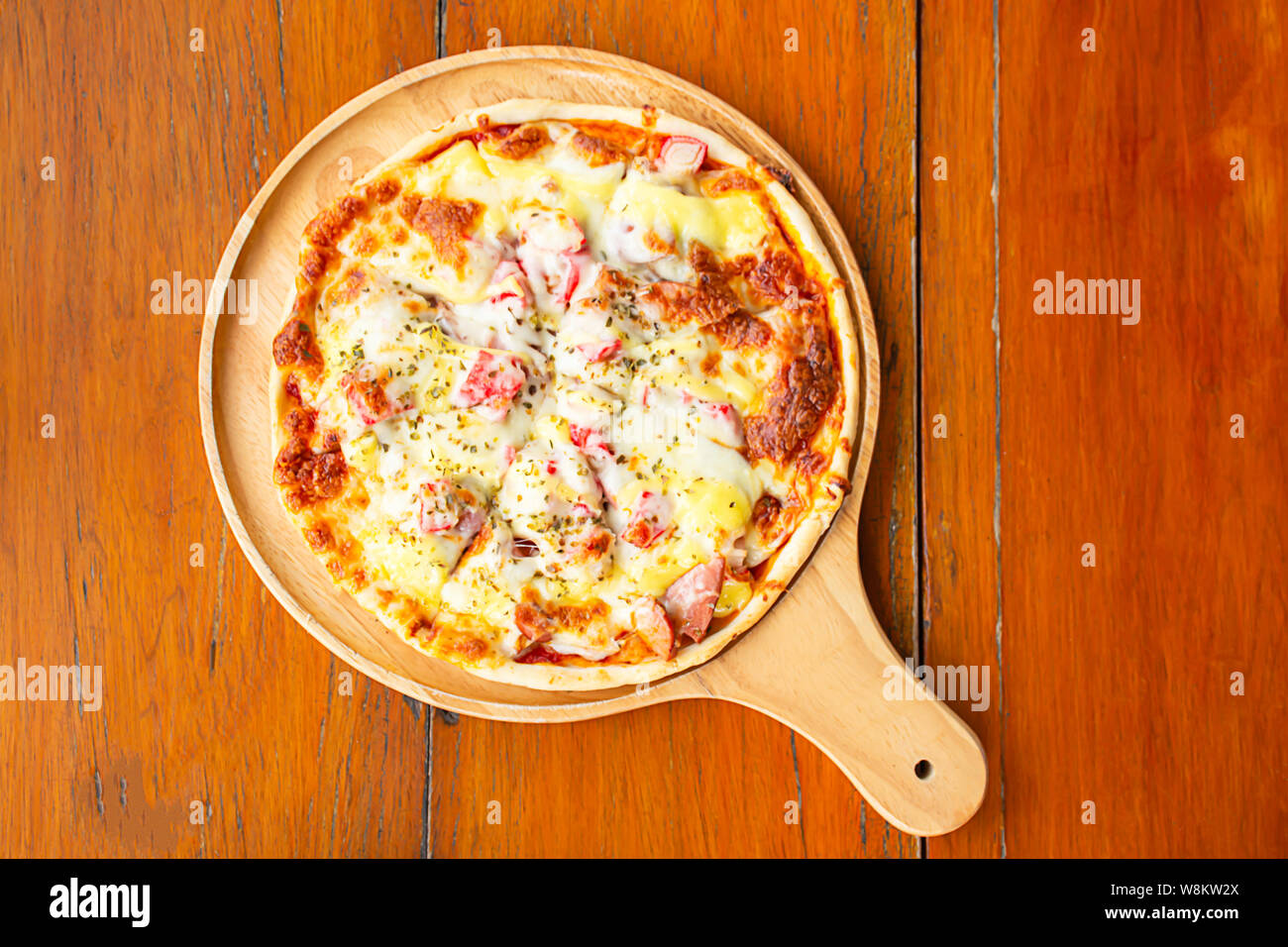 Pizza  ham on the wooden tray is placed on the table. Stock Photo