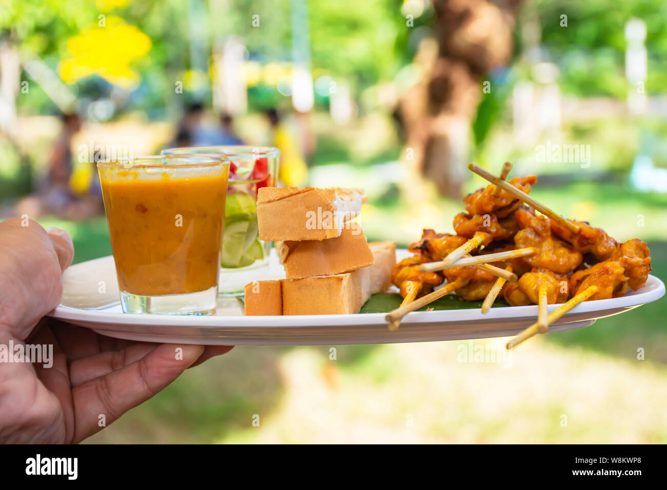 Pork Satay with coconut milk and bread with peanut dipping sauce on