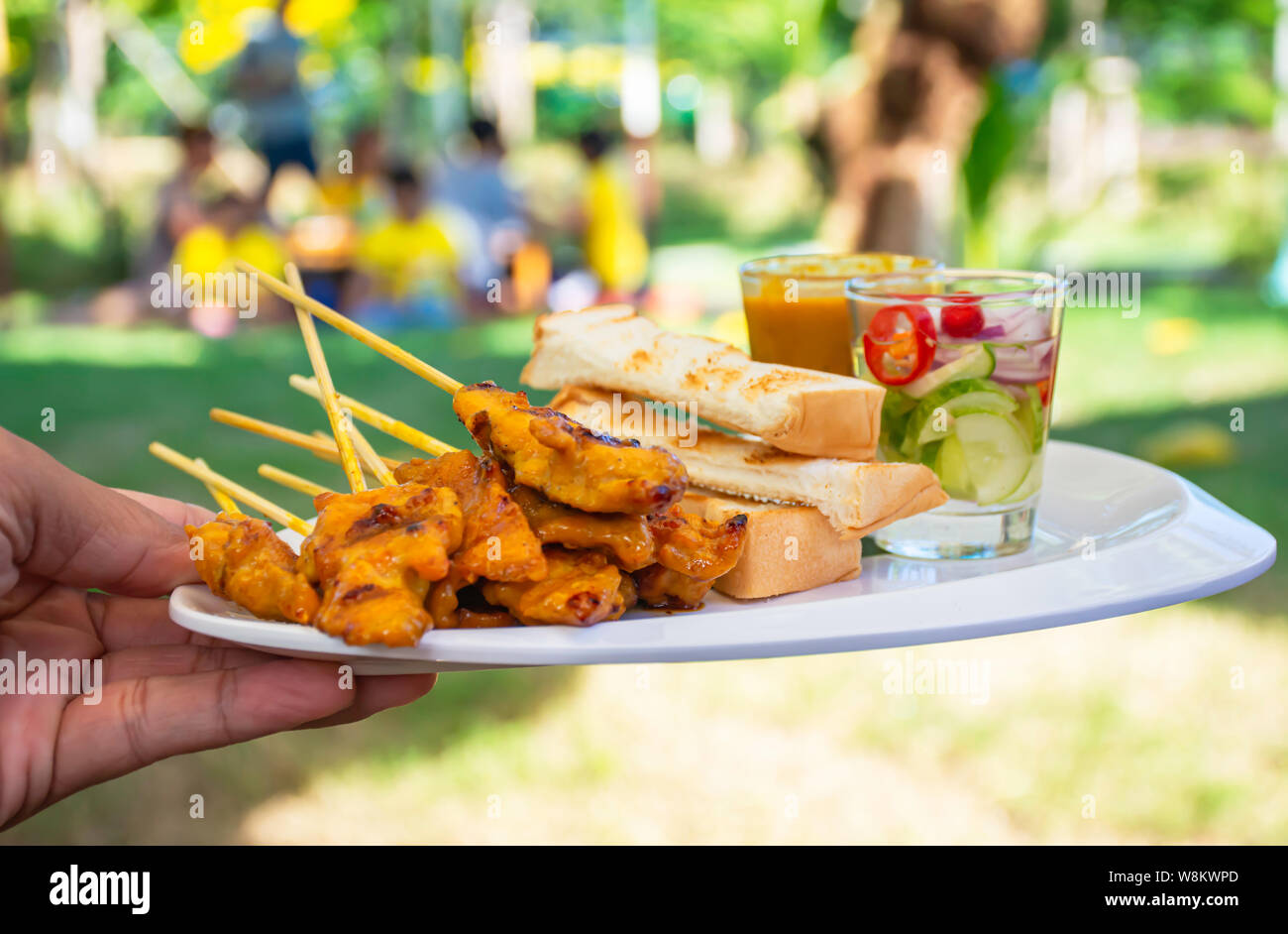 Pork Satay with coconut milk and bread with peanut dipping sauce on